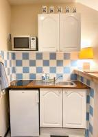 a kitchen with white cabinets and a sink and a microwave at Charmant studio au coeur de Blois in Blois