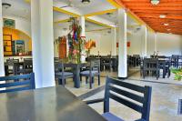 un comedor con mesas negras y sillas azules en Esprit Bentota, en Bentota