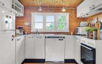 a kitchen with white appliances and a wooden wall at 2 Bedroom Lovely Home In Jgerspris in Hornsved