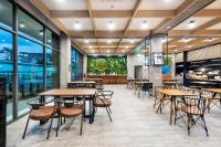 Un restaurante con mesas, sillas y ventanas. en PLAAI Plus Hotel Rayong, en Rayong