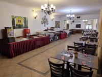 ジェンジェジュにあるBorhotel Sziluett Farkasmályのテーブルと椅子とビュッフェのあるレストラン