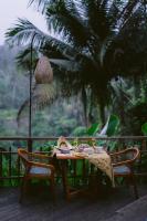 een tafel en twee stoelen op een veranda bij Adiwana Svarga Loka - A Retreat Resort in Ubud