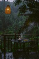 een tafel met eten en een fles wijn op een patio bij Adiwana Svarga Loka - A Retreat Resort in Ubud