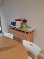 a table with two white chairs and a microwave at CHEZ ROSALIE 