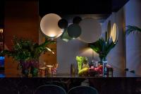 Um bar com balcão, plantas e luminárias pendentes. em Hotel Boutique Párraga Siete em Granada