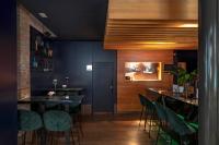 uma sala de jantar com um bar com bancos verdes em Hotel Boutique Párraga Siete em Granada