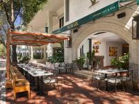 una fila de mesas y sillas fuera de un restaurante en Mayfair House Hotel & Garden, en Miami