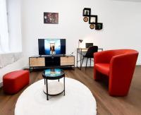 a living room with a red chair and a tv at Beau T2 hypercentre bien équipé in Quimper