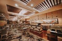 a restaurant with a bar with chairs and a counter at Kingwood Hotel Sibu in Sibu