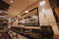 a restaurant with a counter with mirrors on it at Kingwood Hotel Sibu in Sibu