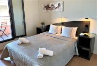a bedroom with a large bed with towels on it at ApartHotel Sainte-Marthe in Avignon