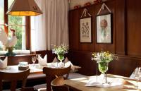 a dining room with tables and chairs with flowers in vases at Seehotel Gut Dürnhof in Rieneck