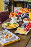 een houten tafel met borden met eten erop bij 1 Lexham Gardens Hotel in Londen