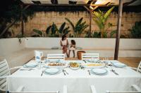 哈马马特DAR BELDI的桌子上摆着几盘食物，背景中有一个女人。