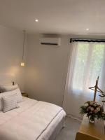 a bedroom with a white bed and a window at Belle vue sur mer, très près du port de Sanary in Sanary-sur-Mer