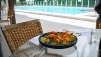 Marambaia Hotel e Convenções في باليريو كامبوريو: طبق من الروبيان على طاولة زجاجية بجوار حمام سباحة