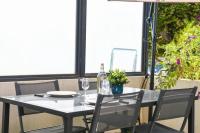 une table avec deux chaises, une bouteille et des verres dans l&#39;établissement Le Capé-Grand appartement avec terrasse et jacuzzi, à Marseille