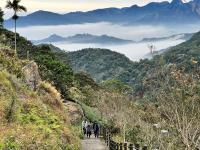 a group of people walking down a mountain trail at Zhong Ming Ju Taoyi Fang in Fanlu