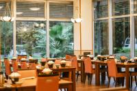 un ristorante con tavoli e sedie in legno e finestre di KAMENOI HOTEL Kanonji a Kanonji