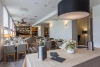 un restaurante con mesas y sillas y una gran lámpara en Hotel pod Lipou RESORT, en Modra
