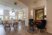 Un comedor con mesas y sillas y un cuadro. en Hotel pod Lipou RESORT, en Modra