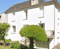 Una casa blanca con un árbol delante. en Spacious 3-Bed House in Chateau Garnier, en Château-Garnier