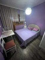 a purple bedroom with a large bed and a chair at Salaš Gnijezdo in Bačka Palanka