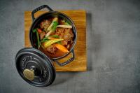 a pot of food sitting on a wooden cutting board at Gasthaus Am Ödenturm in Chammünster