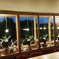 a room with a large window with potted plants at Nederhögen Vildmarkscenter in Rätan
