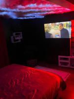 a bedroom with a red bed and a tv at Escapade jacuzzi in Caen