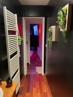 a hallway with black walls and wooden floors and plants at Escapade jacuzzi in Caen