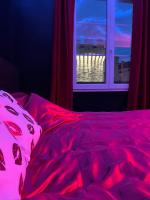 a bed with a red blanket and a window at Escapade jacuzzi in Caen