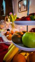 Una mesa cubierta con platos de fruta y un plato de pan. en Hotel und Restaurant Zum Löwen, en Gelnhausen