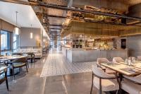 um restaurante com mesas e cadeiras e um balcão em HUALUXE Hotels and Resorts Qingdao Licang em Qingdao