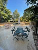 a picnic table with chairs and an umbrella at Maison piscine Lot in Laburgade