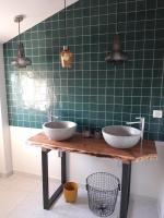 a green tiled bathroom with two sinks on a table at Maison piscine Lot in Laburgade