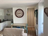 a living room with a table and a clock on the wall at Appartement 1 chambre proximité Port de commerce et Gare SNCF in Brest