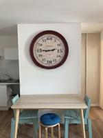 a clock on a wall above a table with two chairs at Appartement 1 chambre proximité Port de commerce et Gare SNCF in Brest