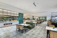 ein Restaurant mit Tischen und Stühlen und einer Küche in der Unterkunft Yuehua Hotel Xiamen Seaside in Xiamen