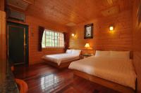 a bedroom with two beds in a wooden cabin at Kingtaiwan Hotel in Lugu Lake