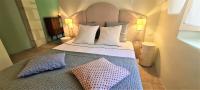 ein Schlafzimmer mit einem Bett mit zwei Kissen darauf in der Unterkunft Villa Aigarden maison d&#39;hôtes in Avignon