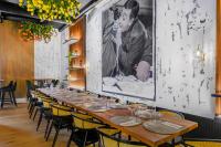 una mesa larga en una habitación con sillas y una pintura en Neuchâtel City Hôtel, en Neuchâtel