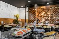 Un restaurante con mesas, sillas y botellas de vino. en Neuchâtel City Hôtel, en Neuchâtel