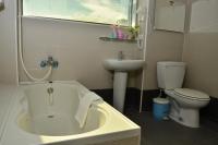 a bathroom with a tub and a toilet and a sink at Fish Fun House in Hualien City