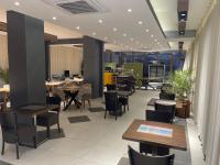 Un comedor con mesas y sillas y un escritorio. en Hotel Story, en Skopje