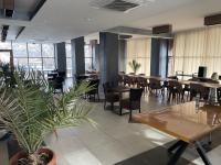 un restaurante con mesas y sillas y una maceta en Hotel Story, en Skopje