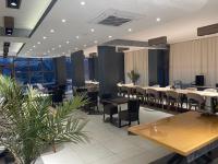 Un restaurante con mesas y sillas en una sala. en Hotel Story, en Skopje