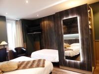 a bedroom with two beds and a large mirror at Logis Hotel Des Bains in Gérardmer