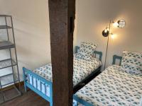 a bedroom with two twin beds and a ladder at Le Logis de Pélagie in Neufchâtel-en-Bray