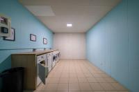a kitchen with blue walls and a tile floor at Le Stratège in Marseille